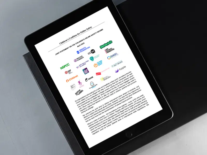 A tablet displaying a joint statement from the Children's Coalition for Online Safety, titled "Joint Statement on the Children’s Online Safety Regime" (April 2025). The document features logos from multiple child protection and advocacy organisations, including NSPCC, Barnardo’s, 5Rights Foundation, CEASE, and more, followed by a block of text urging the Government and Ofcom to keep their promises about children’s online safety.